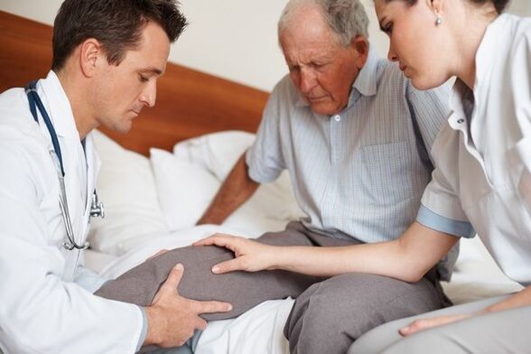 Arzt untersucht Knie des Patienten